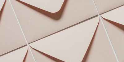 Artistic arrangement of beige envelopes creating a geometric pattern from above view.