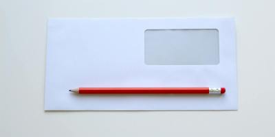 Minimalist photo of a red pencil on a blank white envelope with window. Perfect for stationery themes.